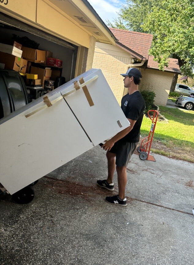 Professional team member carrying a freezer in Magnolia, Texas.